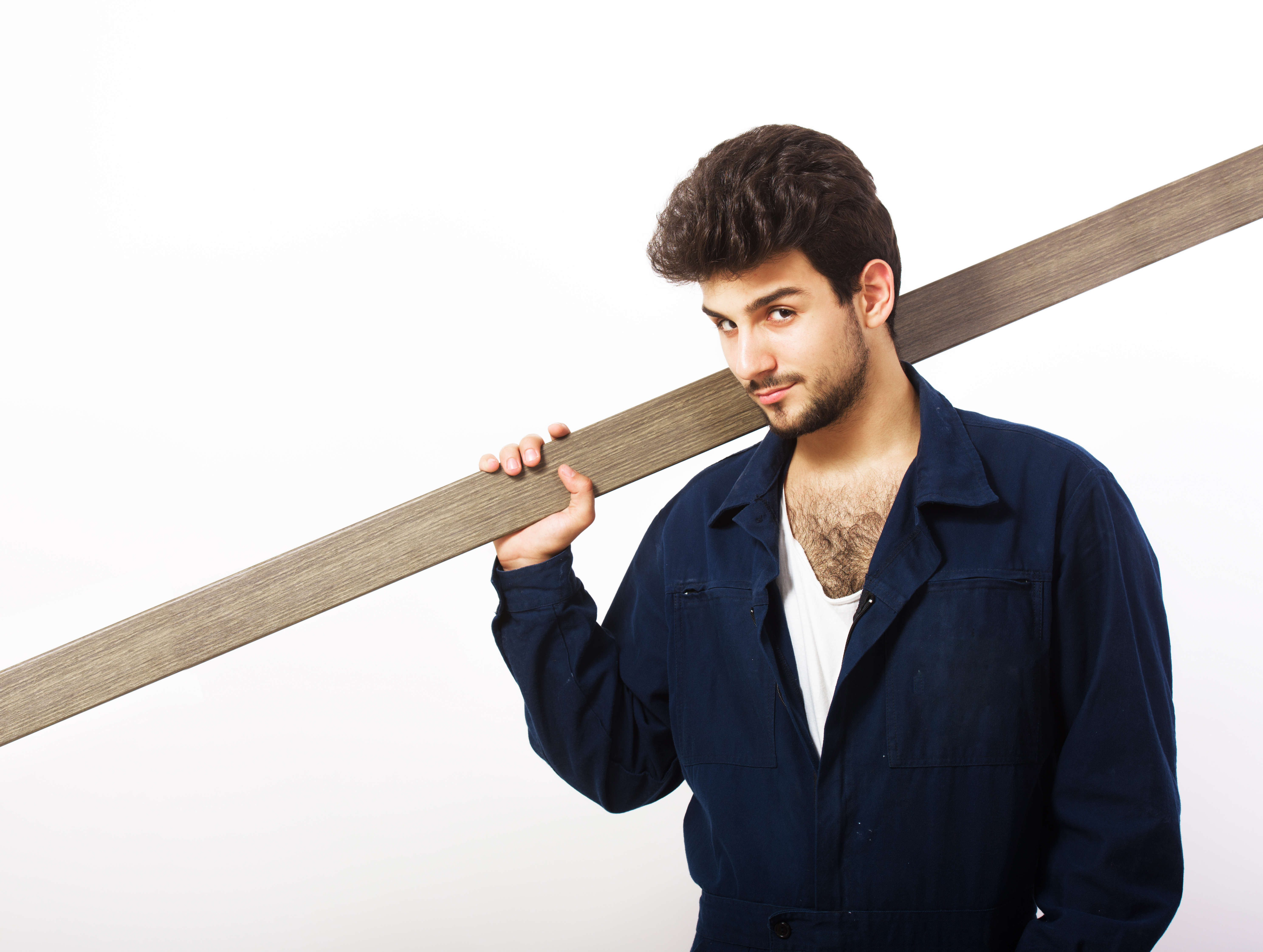 Worker carrying wooden plank confidently