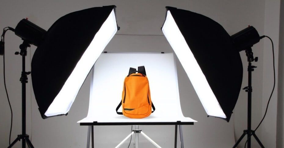 Studio lighting setup featuring a product shoot for an orange backpack