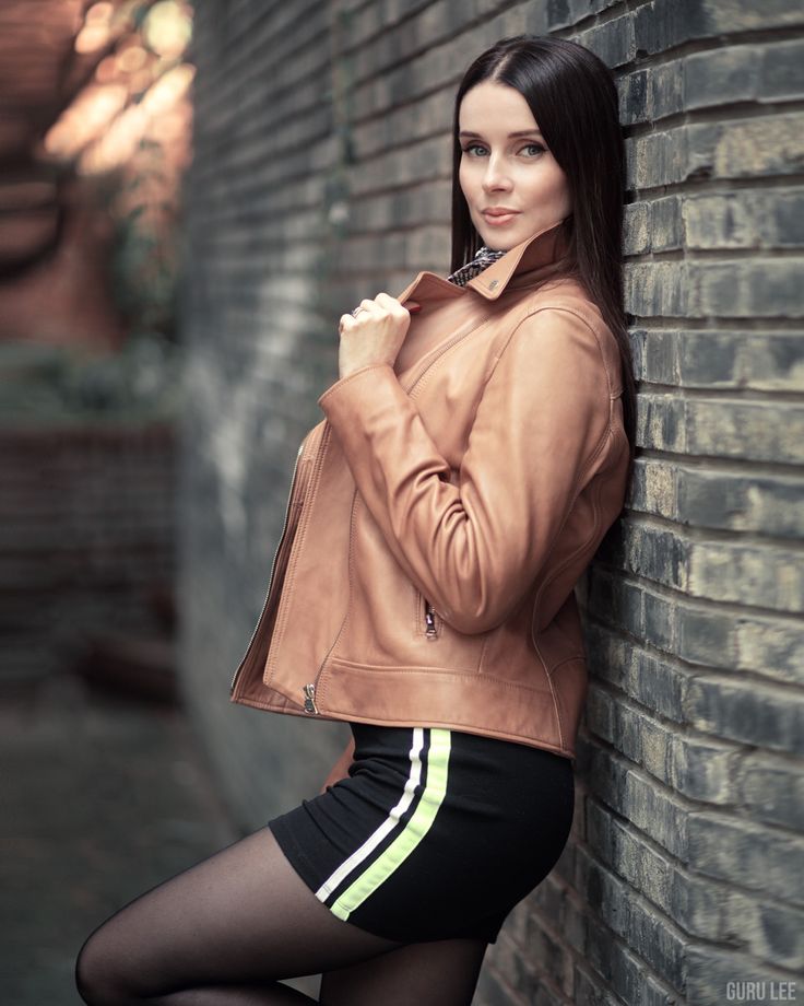 Model posing against a brick wall