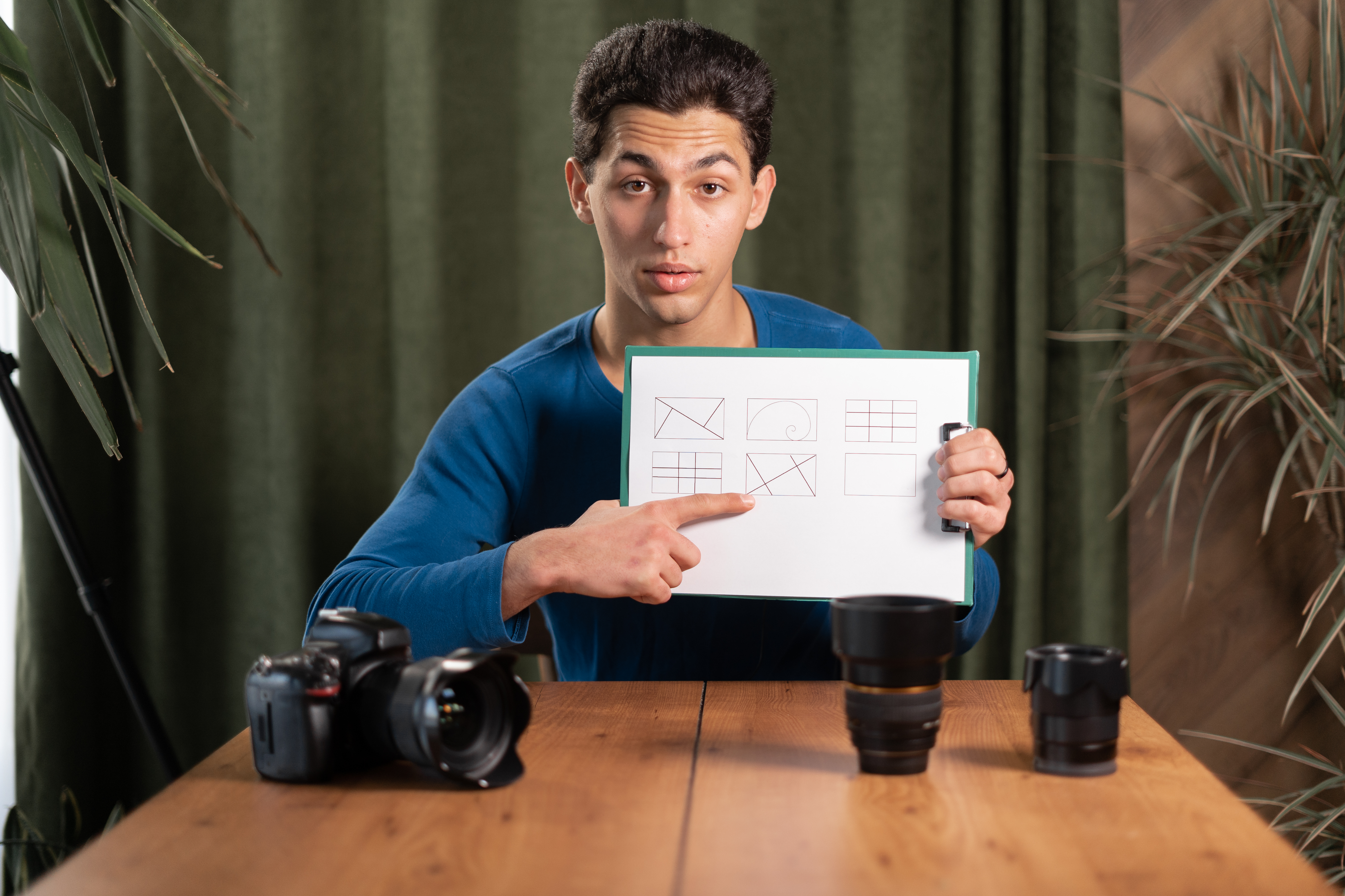 Photographer pointing to a board with composition grids