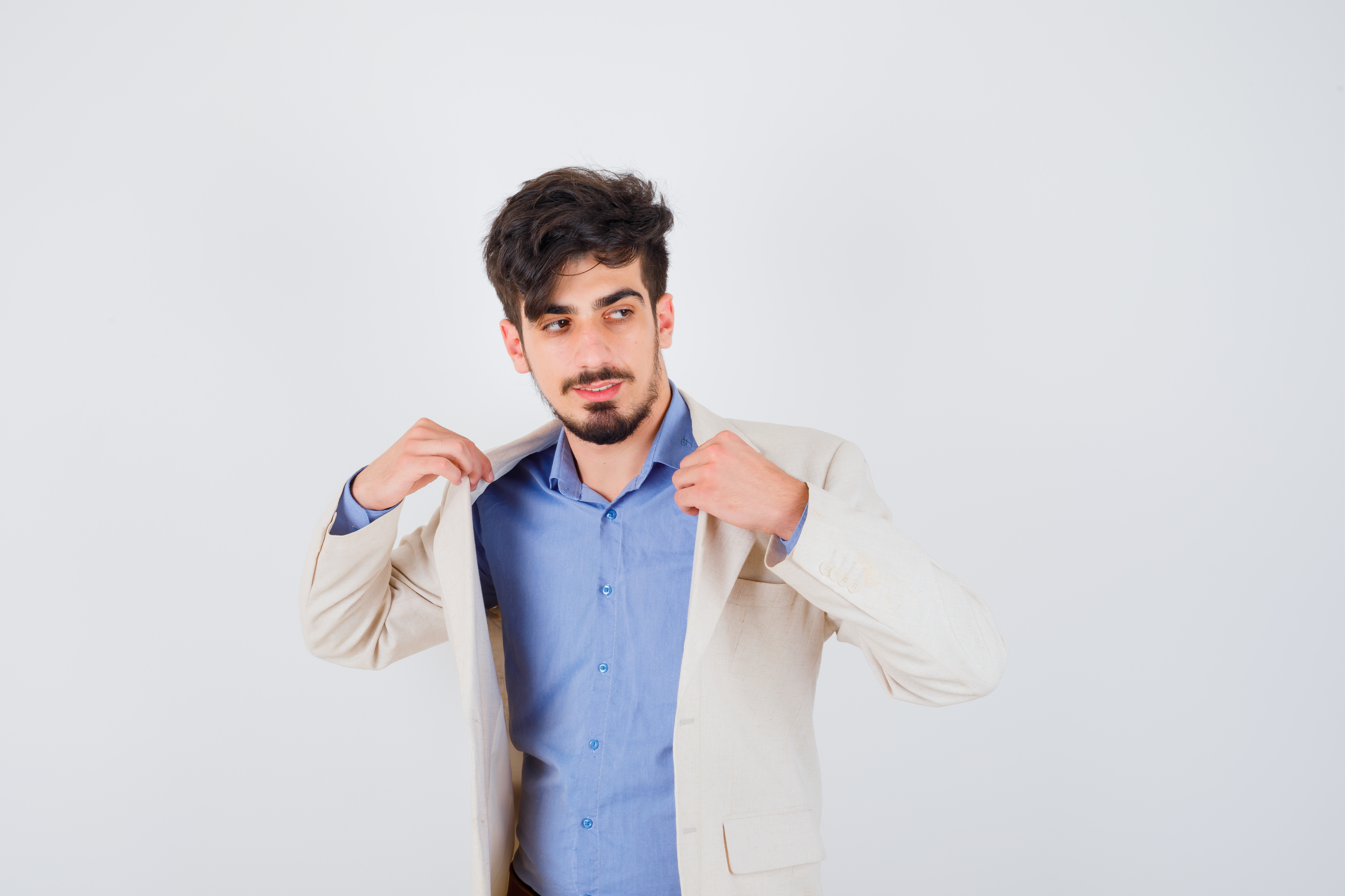 Man fixing beige jacket confidently