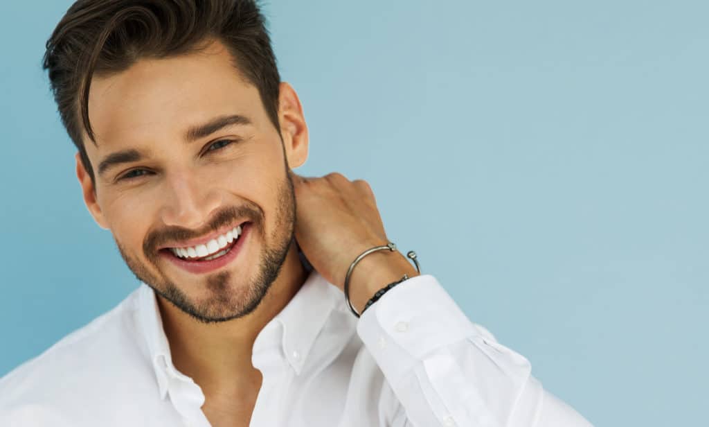 Man smiling confidently in white