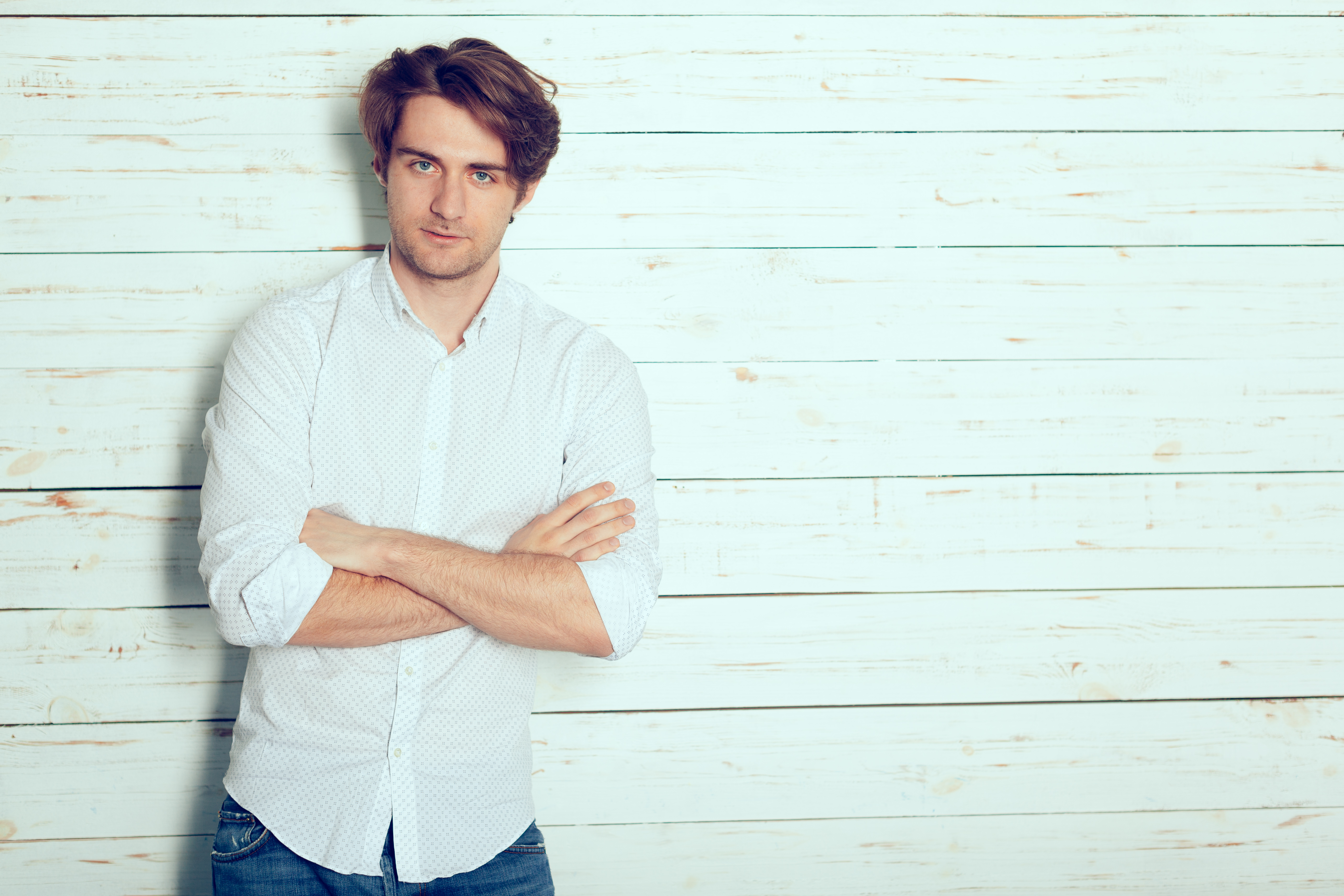 Man leaning against wood backdrop