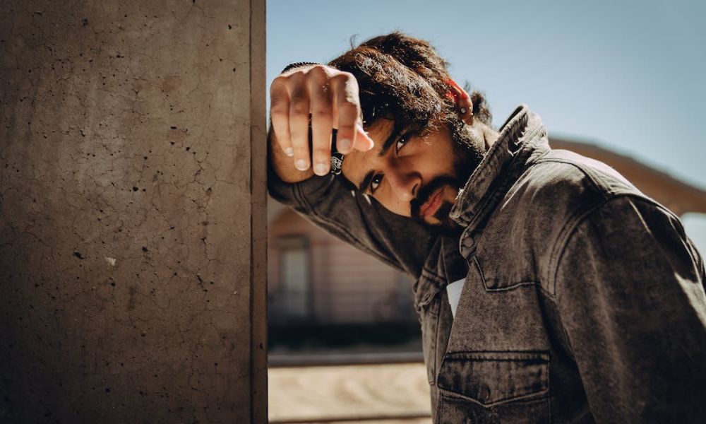 Man leaning against concrete wall