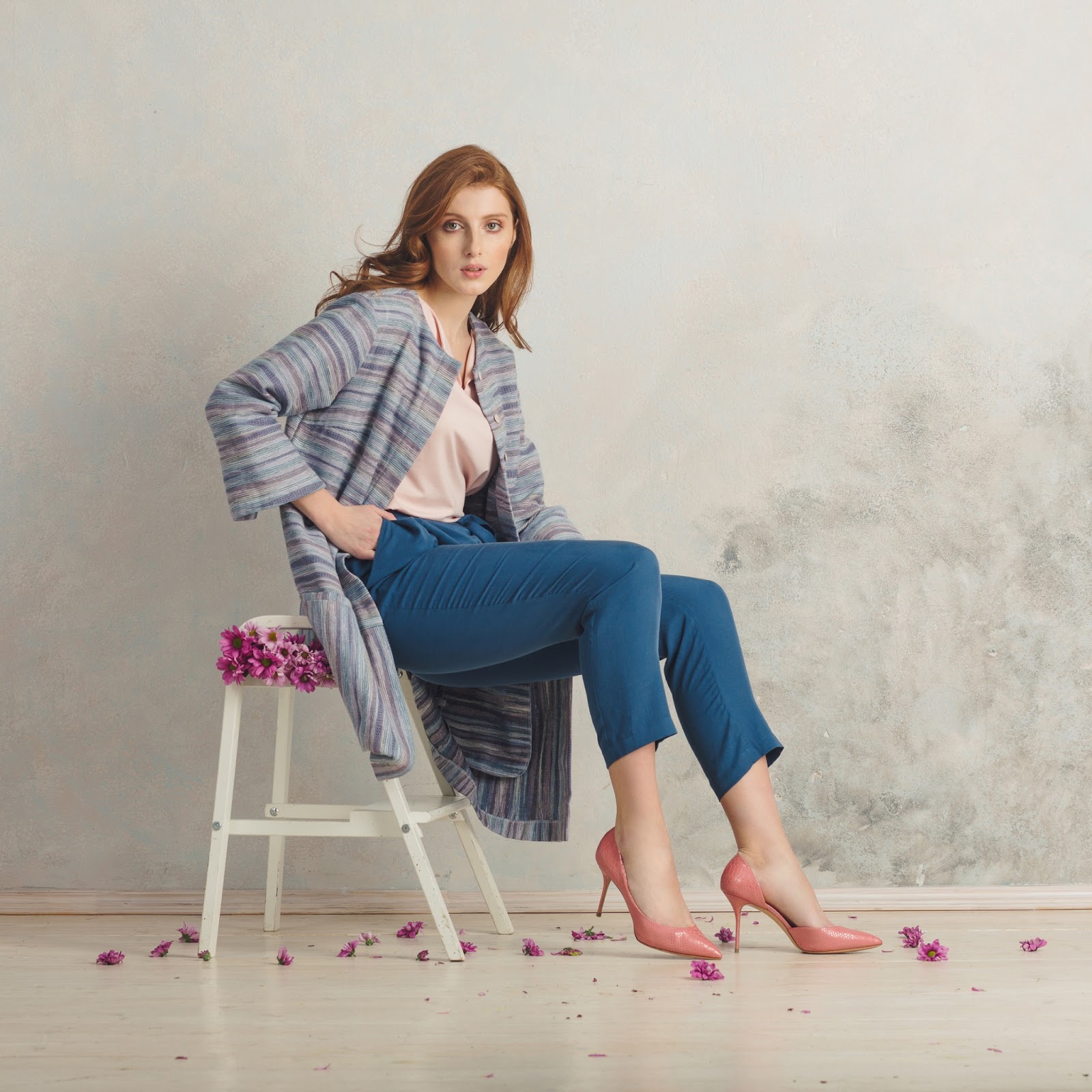 A woman posing for a photoshoot with flowers around her